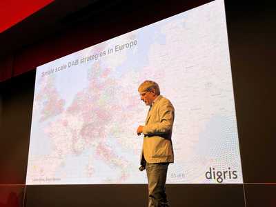 Lukas Weiss of Digris stands on stage at IBC2022 in front of a map of Europe headed small-scale strategies in Europe
