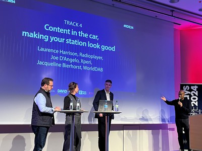 The host on the right of the stage introduces three speakers at podia on stage in the Radio.Content.Car session at Radiodays Europe 2024